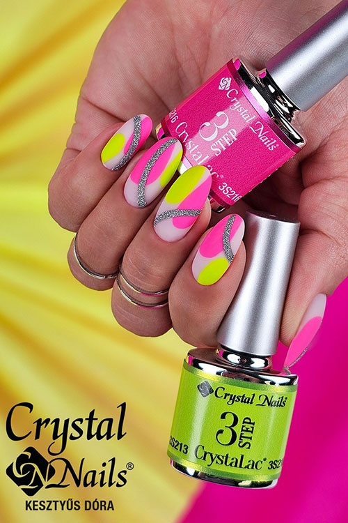 Matte neon pink and yellow negative space nails over a nude pink base color adorned with wide silver glitter swirls