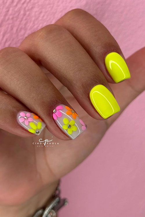 Short square-shaped neon yellow nails with two accent milky white accents adorned with pink, yellow, and orange flowers