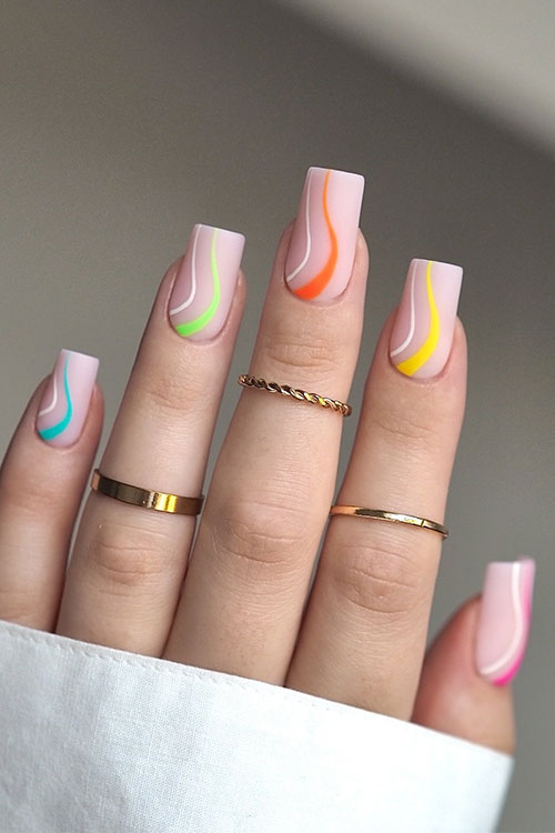 Simple nude nails adorned with white and different neon shades swirls