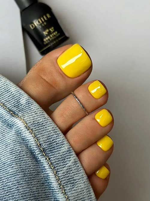 Bright yellow summer pedicure on toenails, exuding a lively and fresh vibe perfect for the warm season.