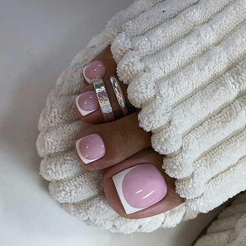 Classy French pedicure toenails over a nude pink base color.