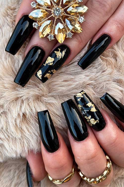 Elegant black coffin nails adorned with gold foil on an accent nail, ideal for a chic fall manicure.