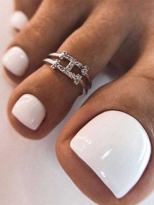 Elegant white pedicure featuring smooth and glossy toenails