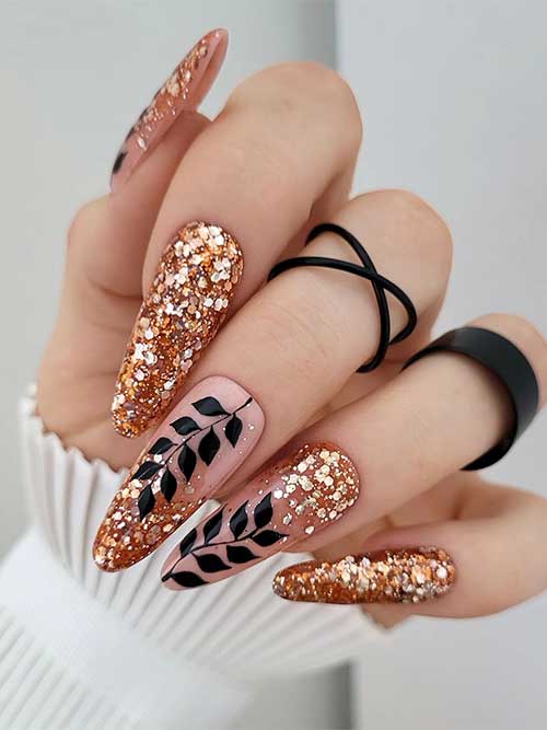 Long almond-shaped copper glitter nails with black leaf nail art