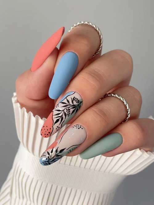 Matte green, blue, and burnt orange almond-shaped nails with black leaf nail art designs