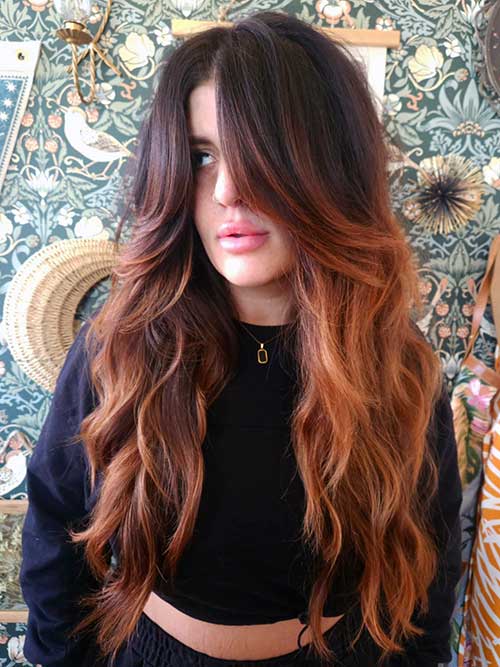 Long shag haircut featuring charming waves and warm hues, creating a trendy and inviting hairstyle.