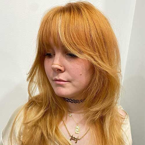 Cute copper long shag haircut for fine hair women, radiating charm and elegance with every strand.