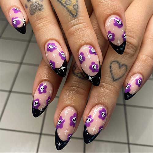 Halloween Black French tip nails are almond-shaped with mini skull flowers and white stars.