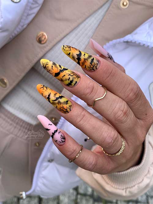 Long matte bat Halloween nails over yellow and nude pink nails.