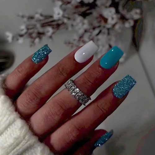 Glossy blue squoval press-on nails featuring a glitter design, perfect for celebrating New Year's Eve in style.