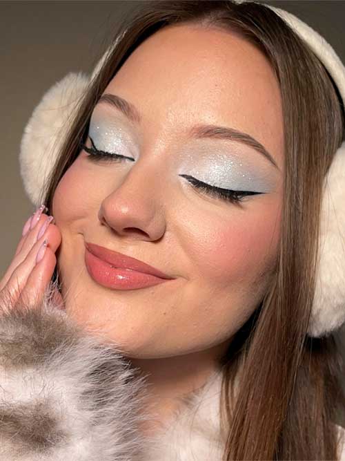 A stunning winter makeup look showcasing icy blue eyes, perfect for a frosty, glamorous vibe.