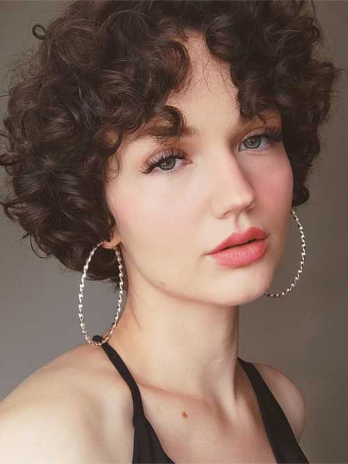 A trendy short curly bob hairstyle, featuring bouncy curls that frame the face elegantly.