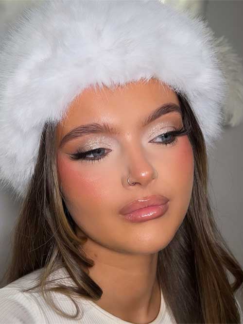 Cool winter makeup with a soft baddie aesthetic, highlighting gold shimmer on the eyes and nude lips for a fresh look.