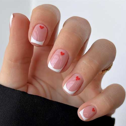 Cute Valentine press on nails featuring short square white French tips, pink hearts, glossy finish, and 24 pieces.