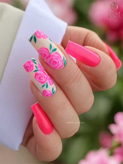 Bright pink nails with cheerful energy, featuring accent nails with delicate rose designs and green leaves on a nude base.