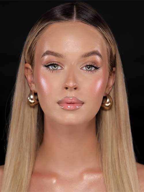 Close-up of a model's glowing skin in a spring makeup style, highlighting the trend of achieving a luminous, glass-like finish.