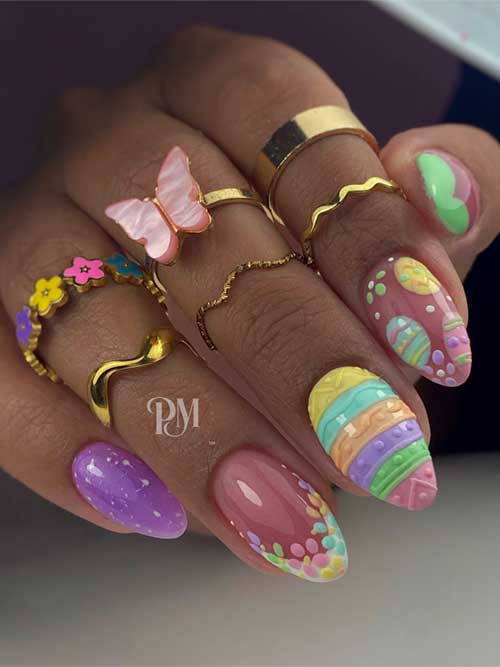 Colorful Easter-themed nails feature striped thumb, pink polka dots, floral accents, green butterflies, and lavender speckles