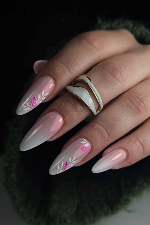 Long almond-shaped nails with a pink-to-white gradient, floral accents, and gold details, resembling a blossoming garden.