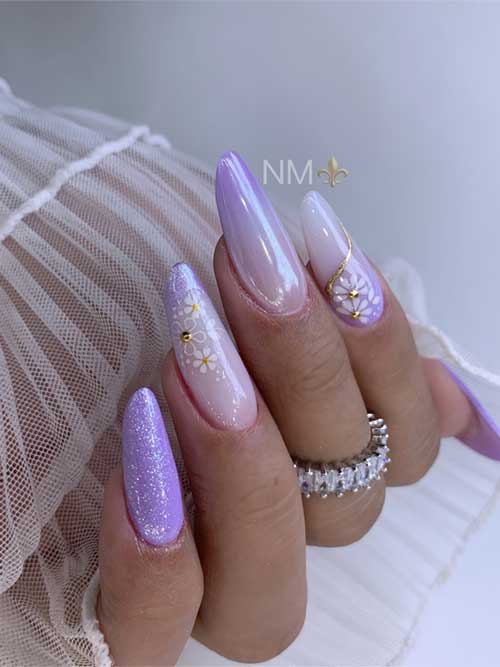 Long almond-shaped purple-white gradient spring nails, adorned with daisy flowers, glittery accents, and a chic gold line.