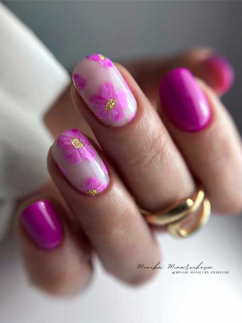 Vibrant pink nail art with floral accents and gold details on a clear base, showcasing a fresh and elegant seasonal design.